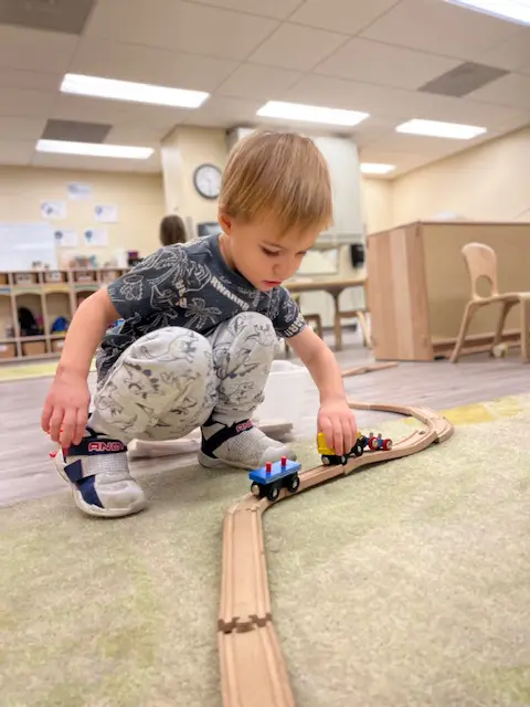 Toddler playing with toy trains